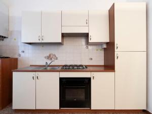cocina con armarios blancos y fogones en Apartment Le due Sorelle by Interhome, en Montalto Ligure