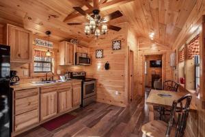 a kitchen with wooden cabinets and a ceiling fan at Sweet Pea Tiny Home in Bryson City