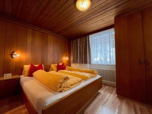 Schlafzimmer mit einem Bett mit gelben und roten Kissen in der Unterkunft Apartment Scheiber - SOE131 by Interhome in Sölden