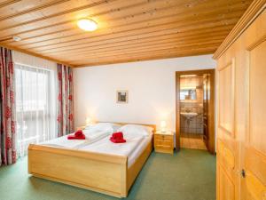 a bedroom with a bed with red pillows on it at Apartment Vorreiter-1 by Interhome in Uttendorf