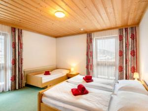 2 Betten in einem Zimmer mit roten Kissen darauf in der Unterkunft Apartment Vorreiter - UTD151 by Interhome in Uttendorf