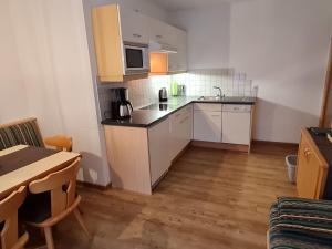 una pequeña cocina con armarios blancos y una mesa en Apartment Walch - PTZ411 by Interhome en Fendels