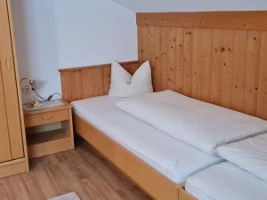 ein Schlafzimmer mit 2 Betten und weißen Kissen darauf in der Unterkunft Apartment Walch - PTZ410 by Interhome in Fendels