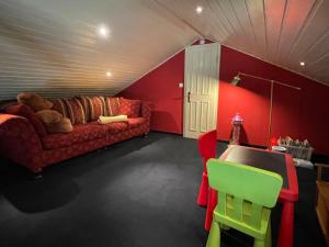 uma sala de estar com um sofá e paredes vermelhas em Holiday Home Klipper by Interhome em Burhave