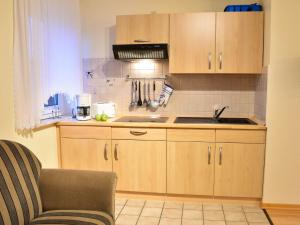 ノルトダイヒにあるApartment Am Nordkap-3 by Interhomeの木製のキャビネットとシンクを備えたキッチン +22枚の写真
