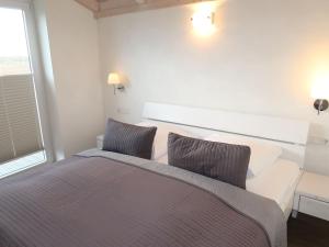a bedroom with a large bed with two pillows at Holiday Home Trottellumme by Interhome in Dagebüll