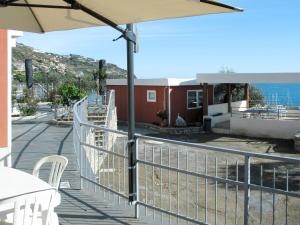 een patio met een parasol en een tafel en stoelen bij Holiday Home Gelsomino - SLR403 by Interhome in San Lorenzo al Mare