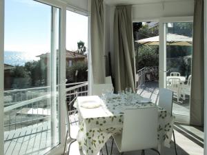 een witte eettafel en stoelen op een balkon bij Holiday Home Gelsomino - SLR403 by Interhome in San Lorenzo al Mare