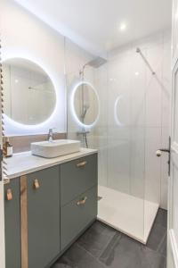 La salle de bains est pourvue d'un lavabo et d'une douche avec un miroir. dans l'établissement T3 rénové 10min gare Part dieu - Quartier typique, à Lyon