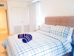 a bed with two pillows on it in a room at Apartamento en Playa Dorada, Green One in San Felipe de Puerto Plata