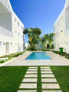 Apartamento en Playa Dorada, Green One في سان فيليبي دي بويرتو بلاتا: مسبح في ساحة بجانب مبنى