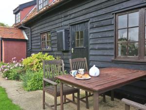 a wooden table with two chairs and a plate of food at Holiday Home Eelsfoot by Interhome in Hemley