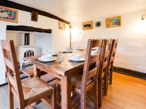 a dining room with a wooden table and chairs at Holiday Home Eelsfoot by Interhome in Hemley