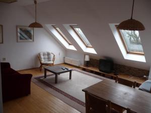 een woonkamer met dakramen en een bank en een tafel bij Apartment Hodkovičky by Interhome in Praag