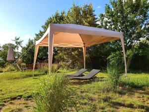 een tuinhuisje met stoelen en een parasol in een veld bij schmiede1860 in Groß Dratow