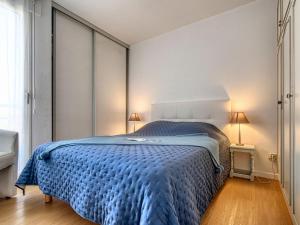 a bedroom with a bed with a blue comforter at Apartment Le Cesarée-2 by Interhome in Fréjus