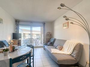 a living room with a couch and a table at Apartment Le Cesarée-2 by Interhome in Fréjus