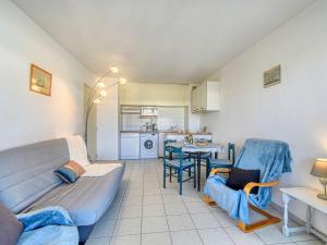 a living room with a couch and chairs and a kitchen at Apartment Le Cesarée-2 by Interhome in Fréjus