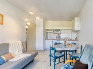 a living room with a couch and a table at Apartment Le Cesarée-2 by Interhome in Fréjus