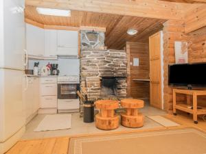 a kitchen with a stone fireplace in a log cabin at Holiday Home Ruka-kitkan lomamajat-tilhi by Interhome in Säkkilänvaara