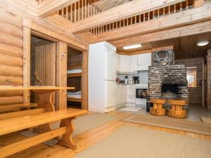 a large wooden room with a wooden table and a fireplace at Holiday Home Ruka-kitkan lomamajat-tilhi by Interhome in Säkkilänvaara
