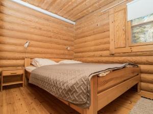 a bedroom with a bed in a log cabin at Holiday Home Ruka-kitkan lomamajat-tilhi by Interhome in Säkkilänvaara