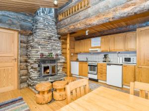 a kitchen with wooden cabinets and a stone wall at Holiday Home Kuontijärvi a by Interhome in Ruka