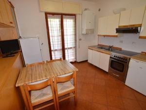 a kitchen with a table and a stove and a refrigerator at Apartment Magnolia by Interhome in Porto dʼAscoli