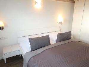 ein Schlafzimmer mit einem Bett mit zwei Kissen in der Unterkunft Holiday Home Wattwurm by Interhome in Dagebüll
