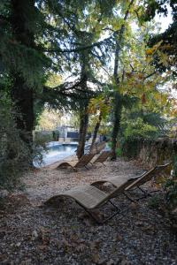 zwei Gartenstühle auf dem Boden neben einem Fluss in der Unterkunft BOX ART ALPINO in Navacerrada