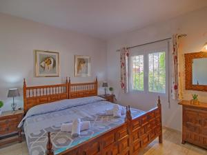 Un dormitorio con una gran cama de madera y una ventana en Villa Estrella by Interhome, en Calpe