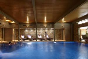 uma mulher ao lado de uma grande piscina em The Greenway Hotel & Spa em Cheltenham