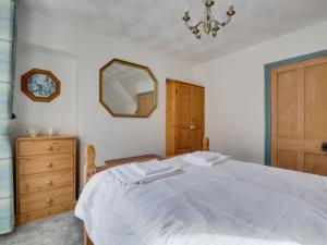 a bedroom with a bed with a mirror and a dresser at Holiday Home Violet by Interhome in Looe