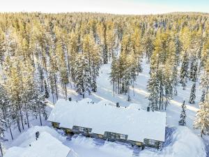 a building covered in snow in a snow covered forest at Holiday Home Teerentie - fun - dasher by Interhome in Äkäslompolo