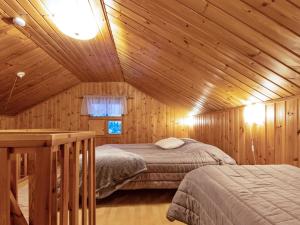 a bedroom with two beds in a wooden cabin at Holiday Home Ylläskarpalo 3 päätyhuoneisto by Interhome in Äkäslompolo +10 photos