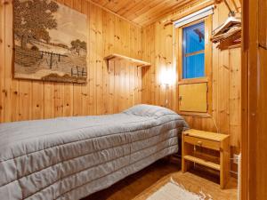 um quarto com uma cama num chalé de madeira em Holiday Home Ylläskarpalo 3 päätyhuoneisto by Interhome em Äkäslompolo