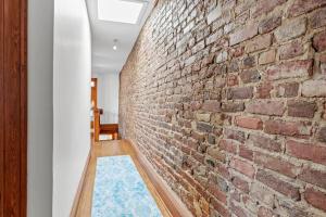 a brick wall in a hallway with a blue rug at Spacious Home in Heart of Historic Fan District in Richmond
