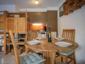 une salle à manger avec une table en bois et des verres à vin dans l'établissement Apartment Jorasse A 1 by Interhome, à Ovronnaz