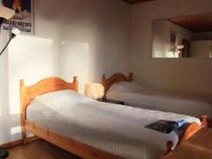 a bedroom with two twin beds and a mirror at Studio La Bercière 7 by Interhome in Villars-sur-Ollon