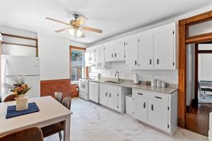 a kitchen with white cabinets and a ceiling fan at Spacious Home in Heart of Historic Fan District in Richmond