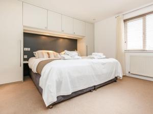 Un dormitorio con una cama grande con sábanas blancas. en Holiday Home Villa Gallery by Interhome, en Perranwell 10 fotos más