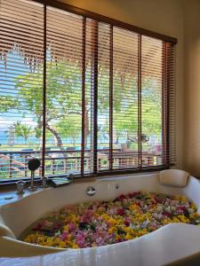 Better View Koh Yao Yai في كو ياو ياي: حوض استحمام مليء بالورود في غرفة بها نوافذ