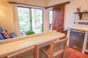 eine Küche mit einem Tisch und Stühlen sowie einem Fenster in der Unterkunft Vida Feliz Casitas in Sayulita