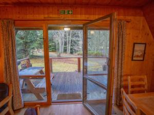 an open door to a porch in a cabin at Chalet Birchwood Cottage by Interhome in Inverness