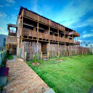 a building with a grass yard in front of it at Kaha Mar - Patacho in Pôrto de Pedras
