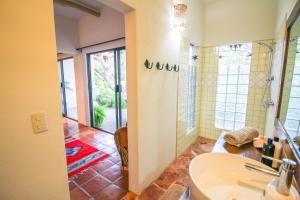 y baño con lavabo y ducha. en Vida Feliz Casitas en Sayulita