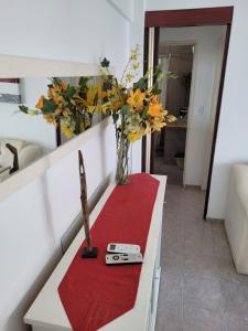 a table with a red carpet and a vase with flowers at Oasis Lodging in Buenos Aires