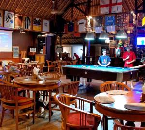 ヌサドゥアにあるPeninsula Beach Resortのビリヤード台、テーブル、椅子が備わるレストラン