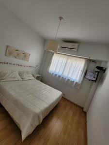 um pequeno quarto com uma cama e uma janela em Oasis Lodging em Buenos Aires