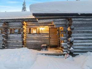 a log cabin with a door in the snow at Holiday Home Lumiankelo by Interhome in Sirkka